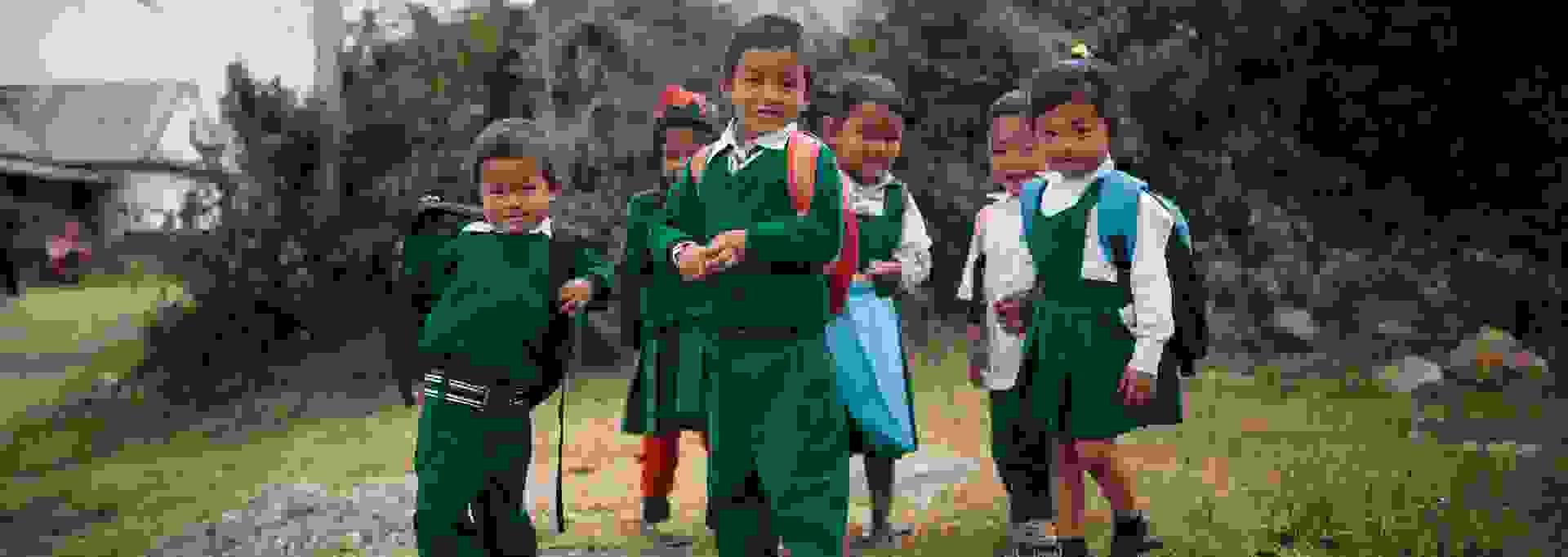Hymyileviä nepalilaislapsia koulumatkalla kouluasuissaan.