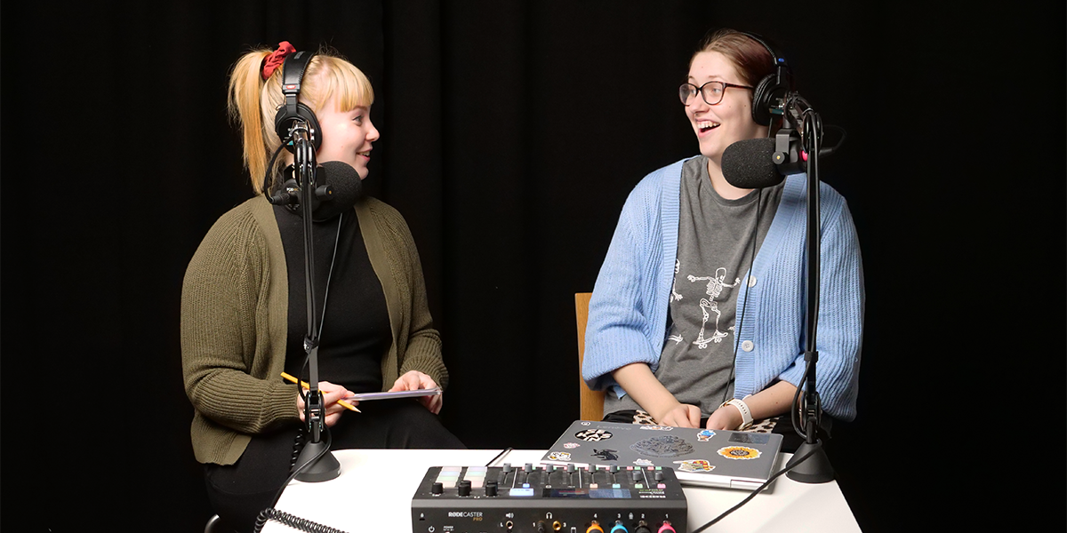 Podcastin juontaja, Nuorten turvatalojen vapaaehtoinen Taika Vaulo sekä j podcastin vieraana ollut Elina Pesonen katsovat toisiaan ja nauravat studiossa.