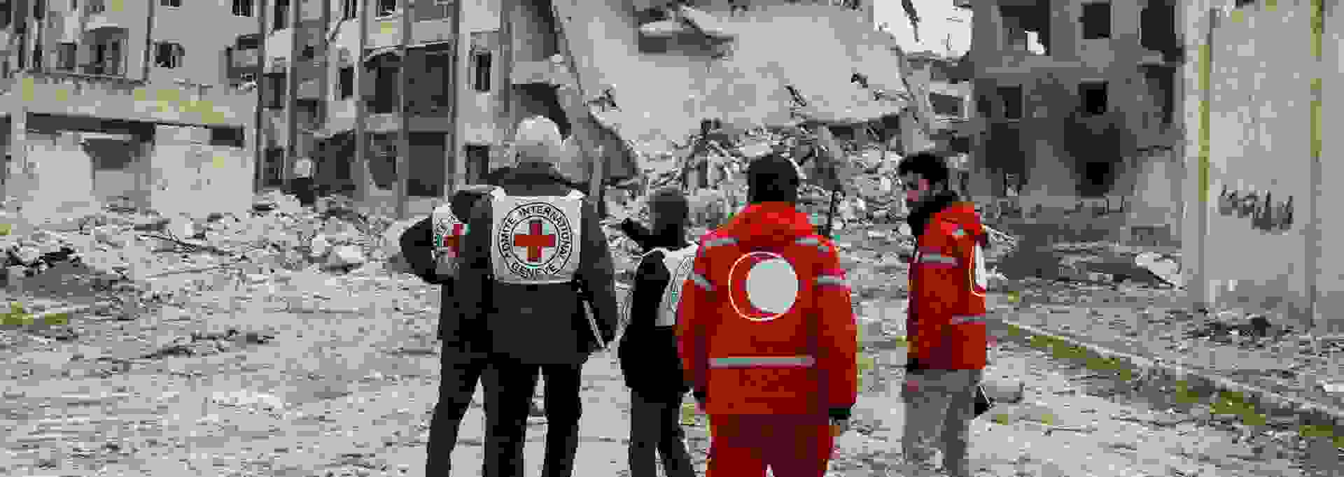 Punaisen Ristin ja Punaisen Puolikuun työntekijöitä konfliktin runtelemassa kaupunkimaisemassa.