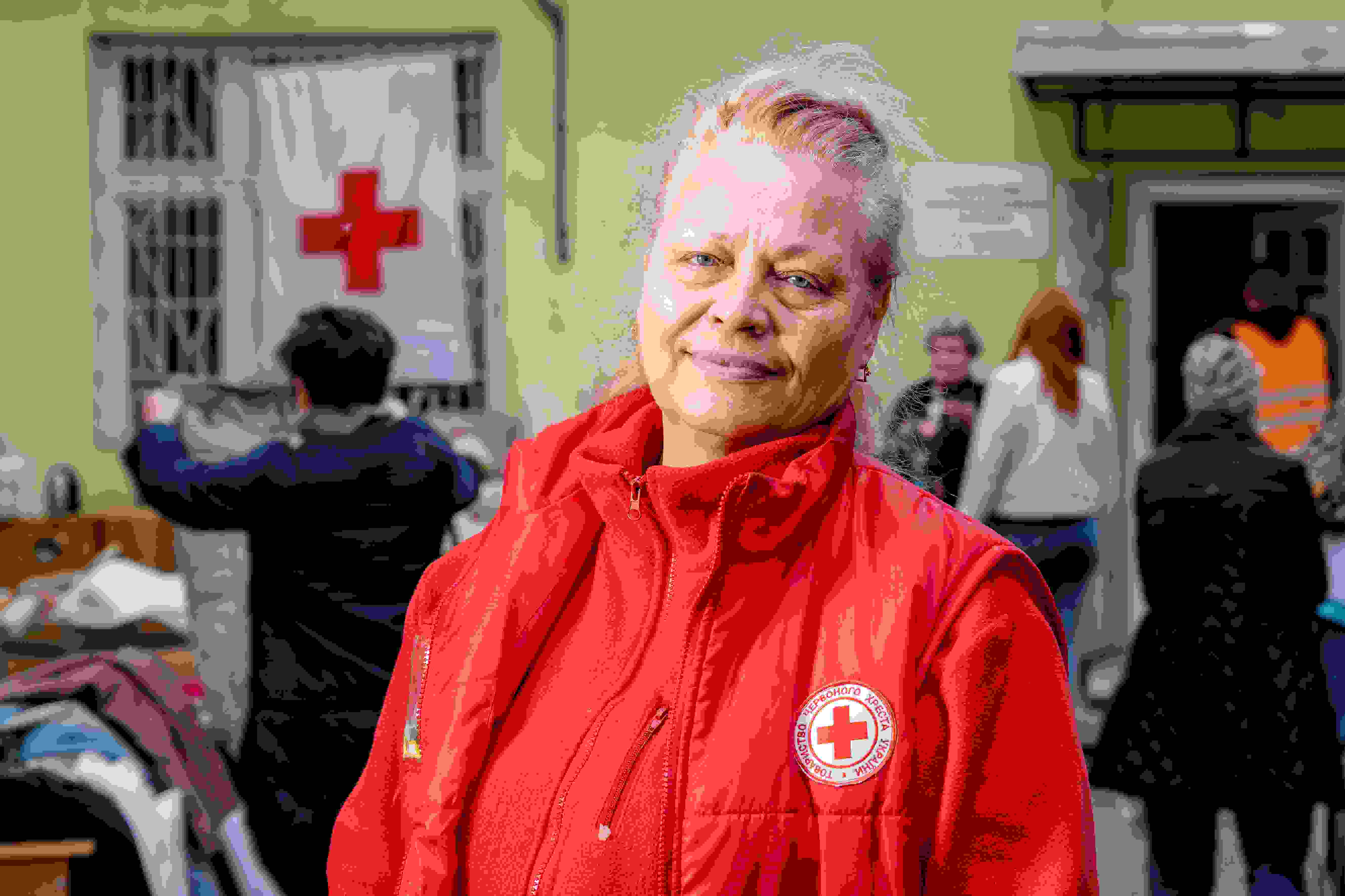 Nainen puolilähikuvassa Punaisen Ristin liivissä.