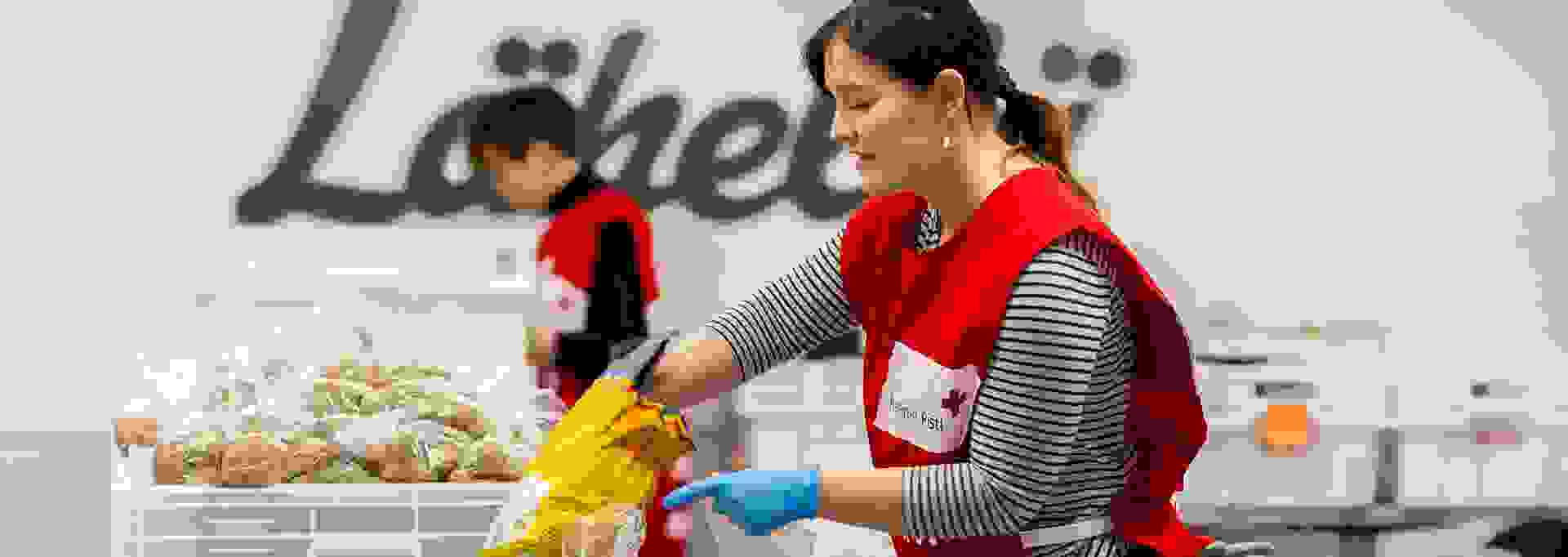 Punaisen Ristin vapaaehtoiset jakavat ruokakasseja.