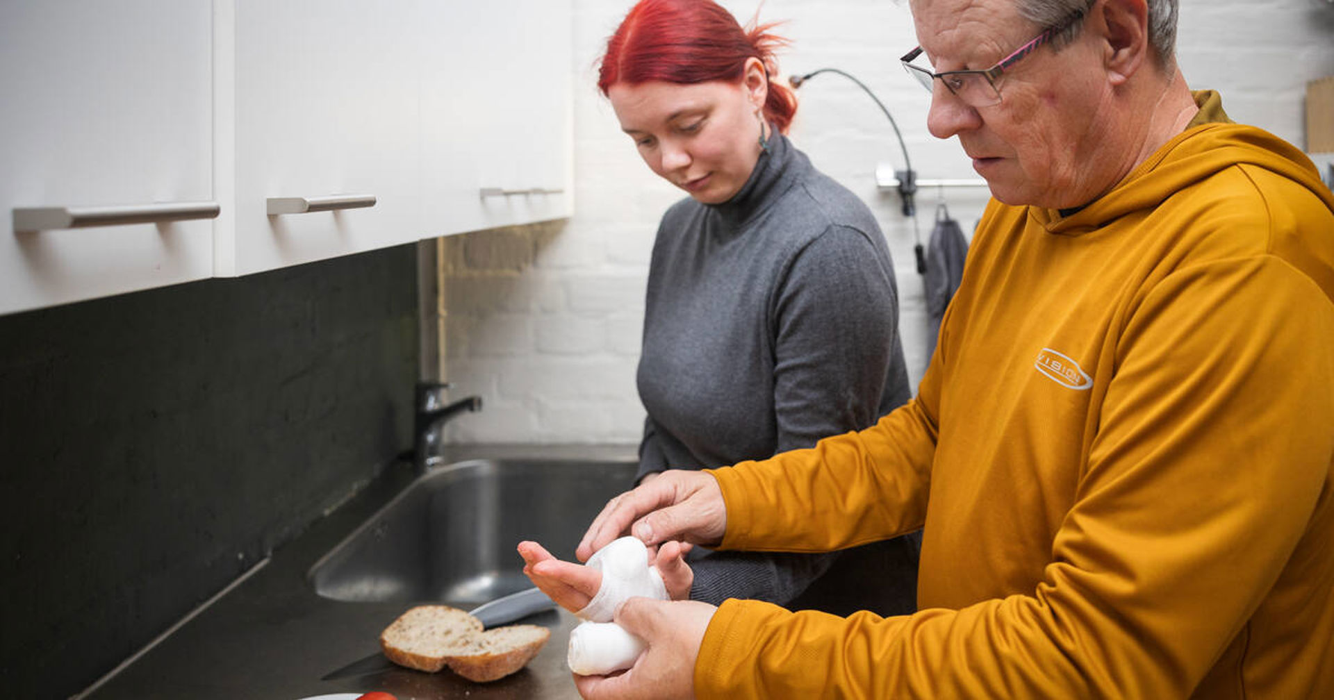 Kaksi lasta harjoittelee käteen tulleen haavan sitomista sideharsolla.