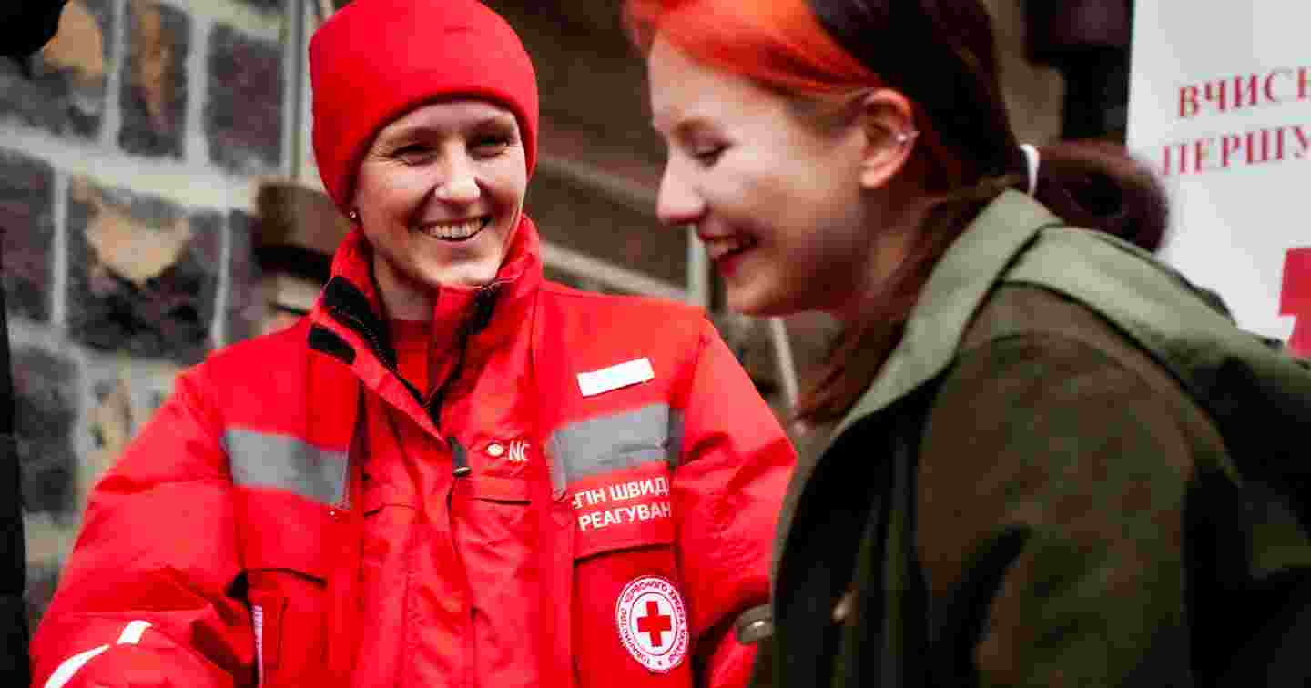 Ukrainan Punaisen Ristin vapaaehtoinen keskustelee toisen henkilön kanssa.
