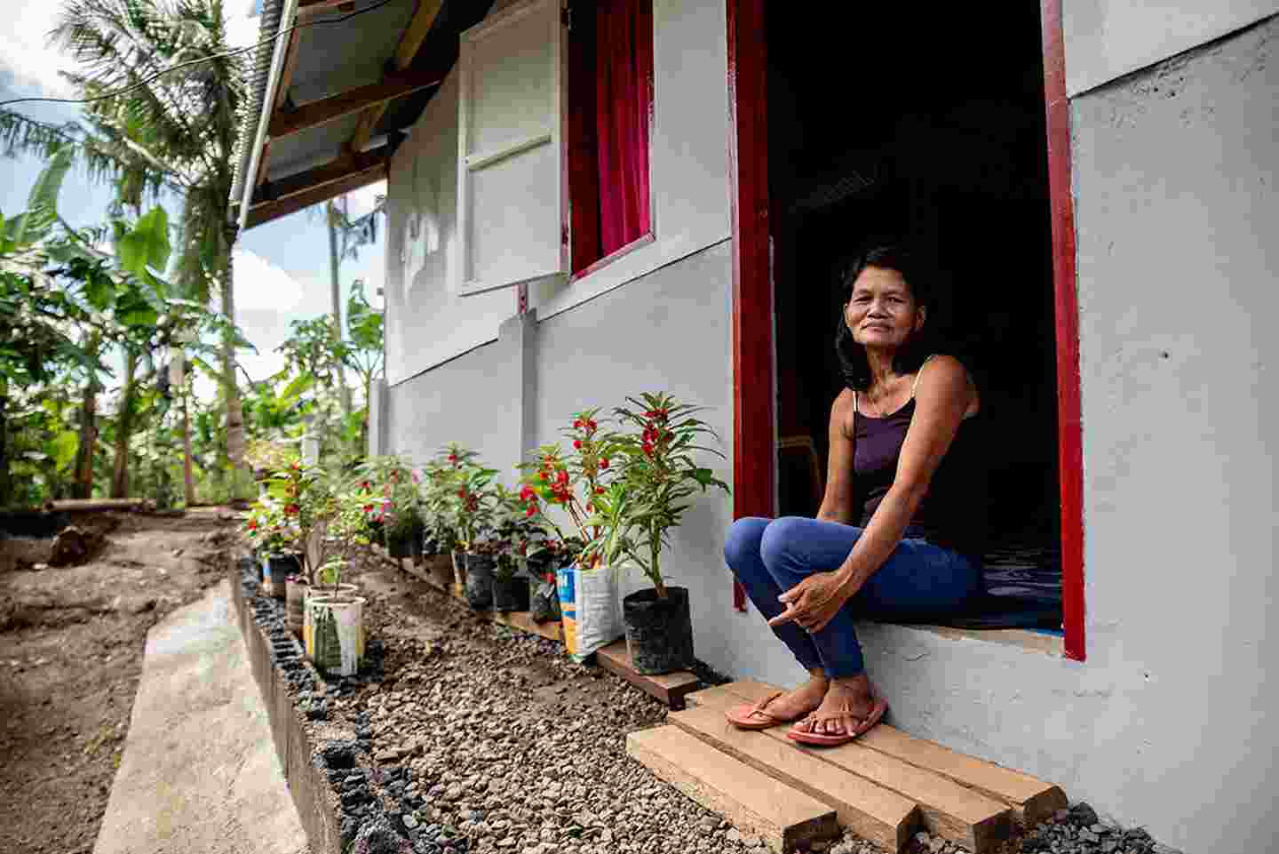 Nainen istuu talonsa edessä Filippiineillä