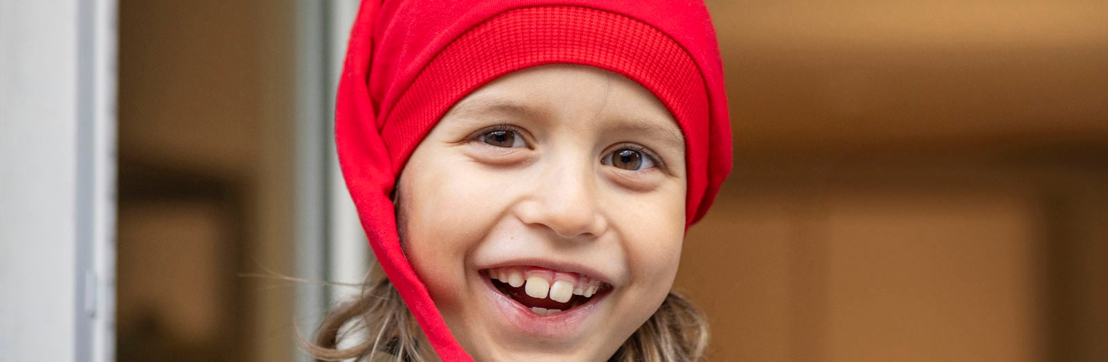 Hymyilevä lapsi tonttulakki päässä.