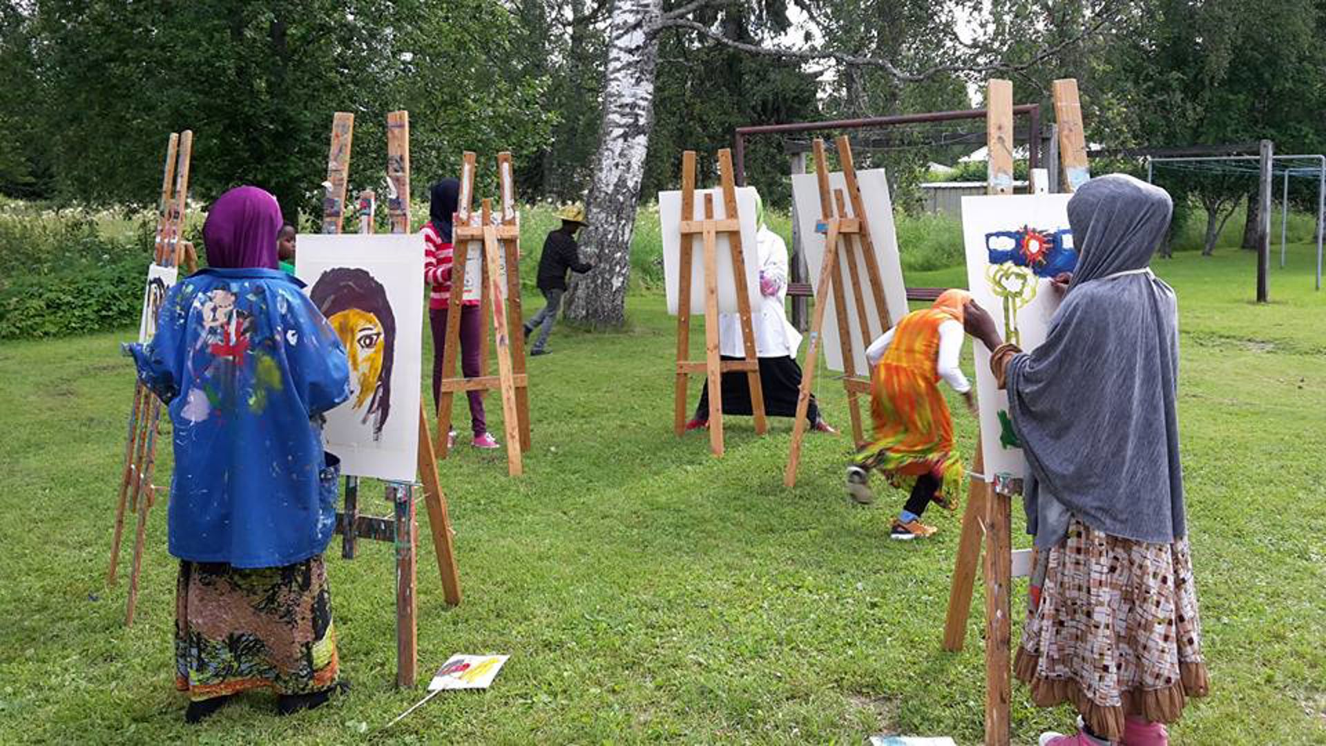 Naiset maalaavat tauluja ulkona