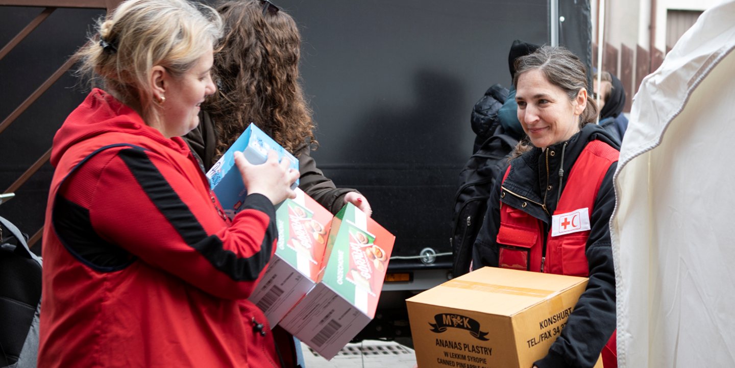 Jenelle Kansainvälisen Punaisen Ristin liitosta auttaa purkamaan avustuskuljetusta Varsovassa, Puolassa.