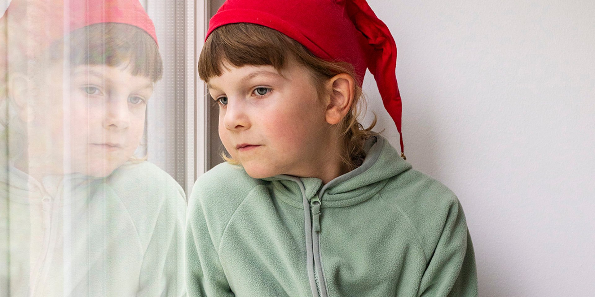 Lapsi katsoo ulos ikkunasta.