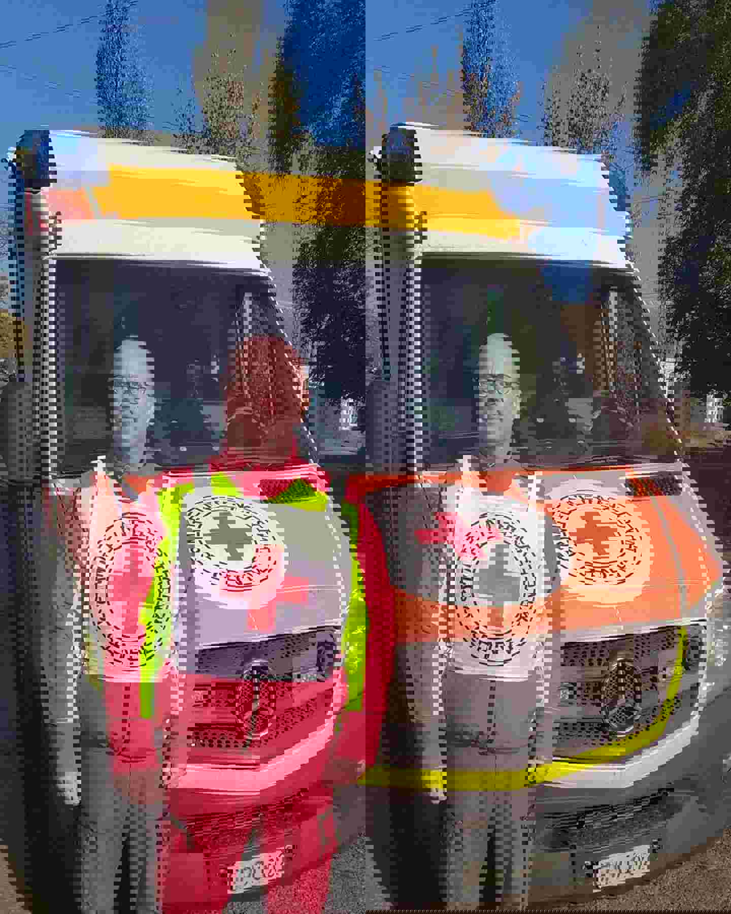 Ensihoitaja Tuomo Hämäläinen hymyilee Punaisen Ristin komitean ambulanssin vieressä
