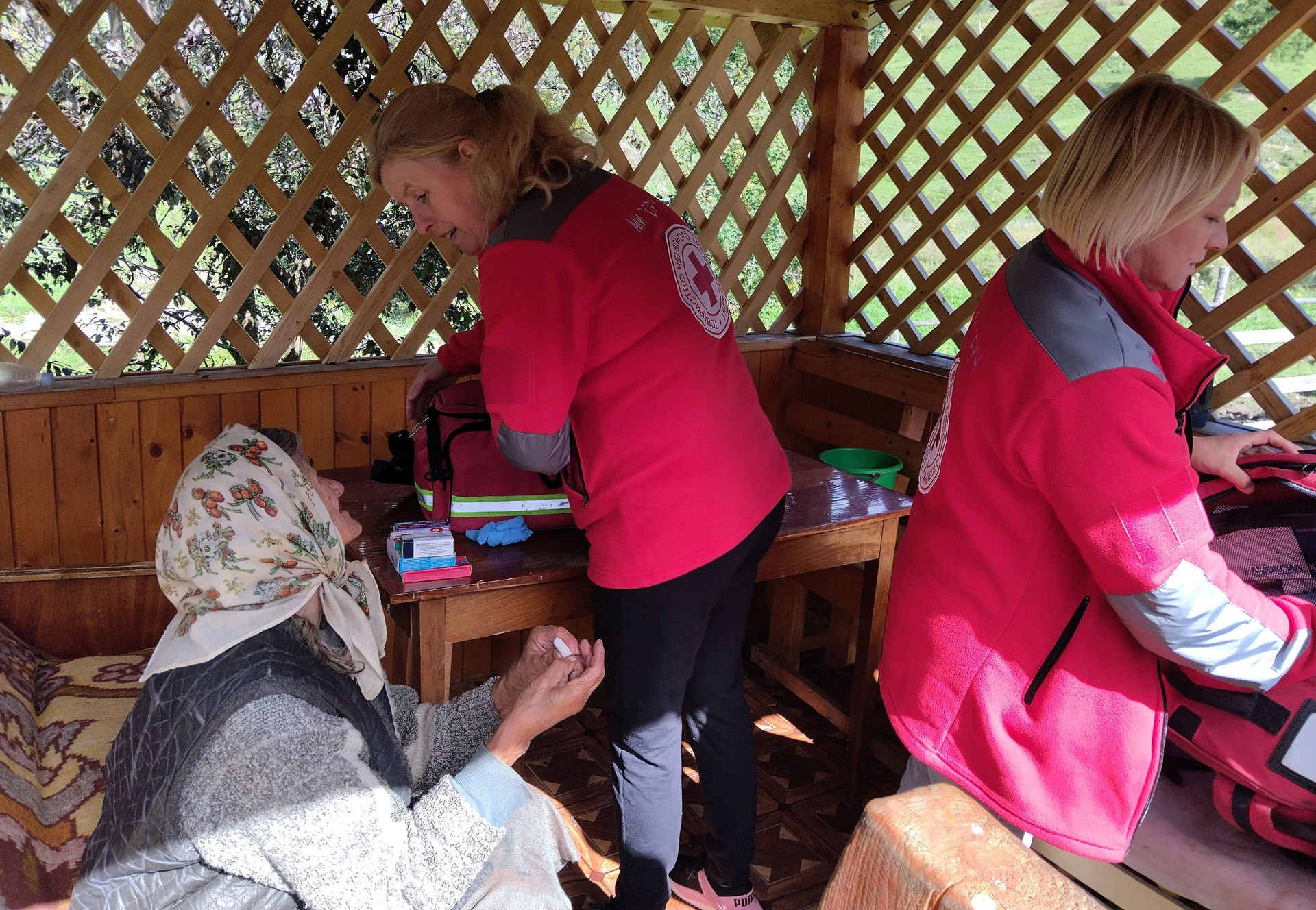 Liikkuvien terveysklinikoiden työntekijät hoitamassa ikäihmistä Ukrainan maaseudulla