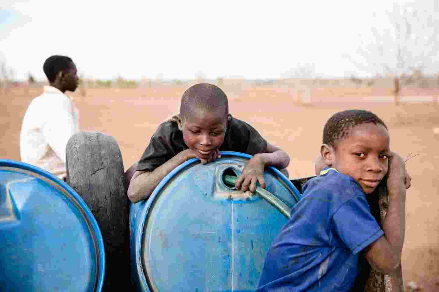 Zimbabwelaisia poikia vesitynnyrin äärellä.