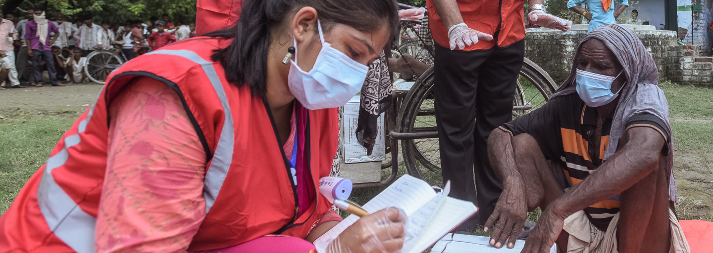Aid worker feeding nutrient solution to a newborn baby.