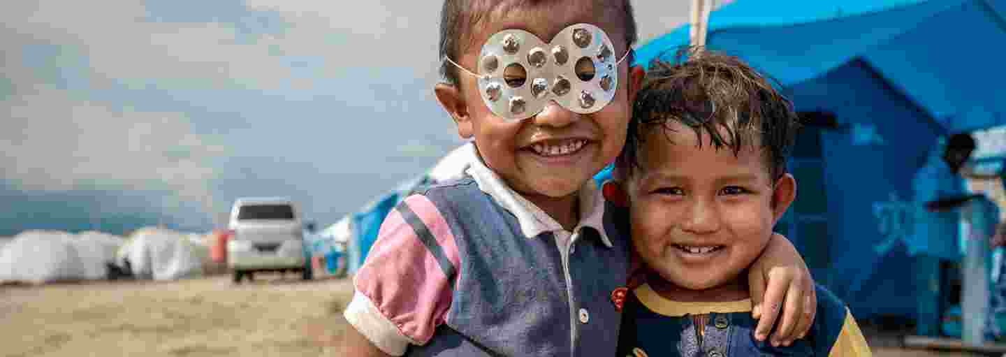 Lapset leikkivät supersankareita pakolaisleirillä.