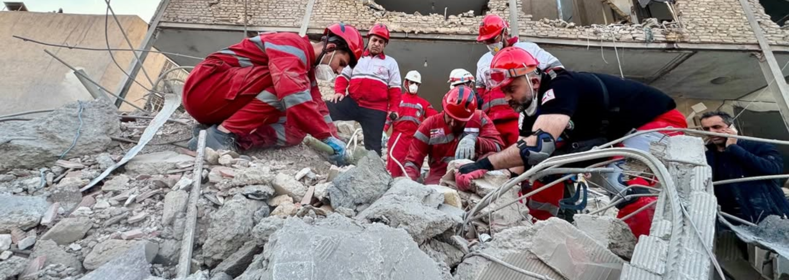 Punaisen Ristin asuihin pukeutuneet vapaaehtoiset etsivät raunioista pelastuneita