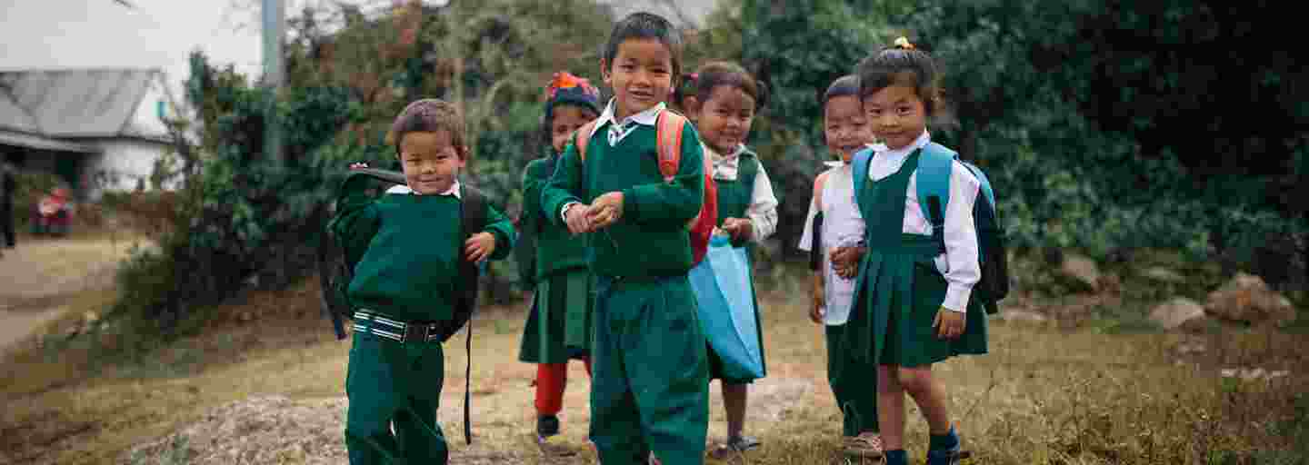 Hymyileviä nepalilaislapsia koulumatkalla kouluasuissaan.