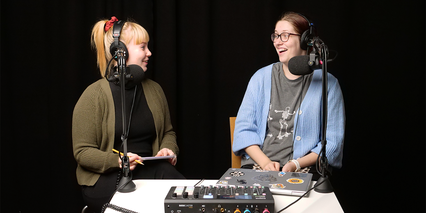 Kuvassa podcastin juontaja, Nuorten turvatalojen vapaaehtoinen Taika Vaulo sekä j podcastin vieraana ollut Elina Pesonen katsovat toisiaan ja nauravat studiossa.