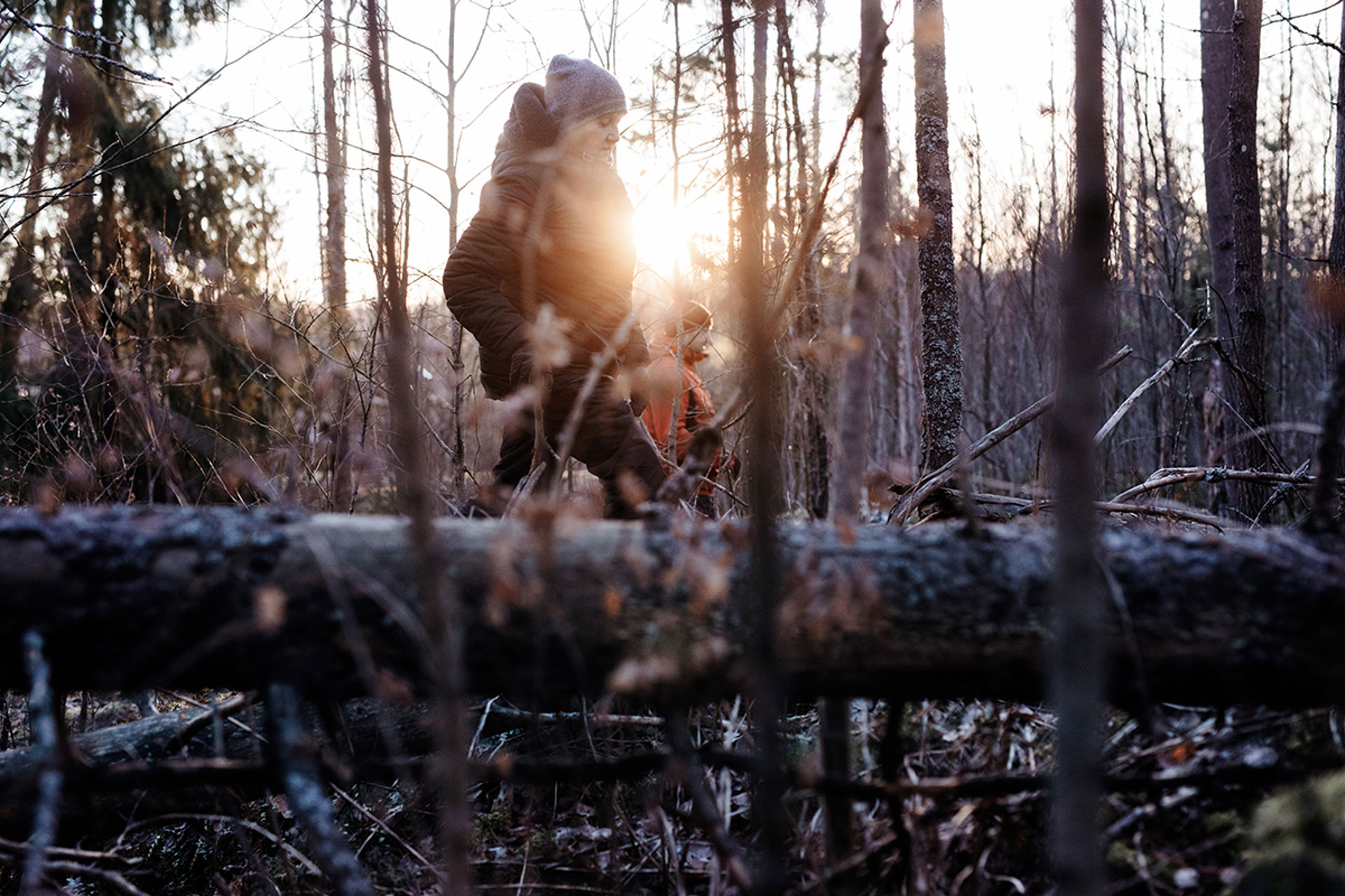 Kaksi henkilöä osallistuu Vapaaehtoisen pelastuspalvelun etsimistoimintaan aurinkoisessa talvimetsässä.