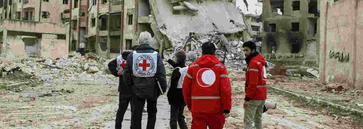 Punaisen Ristin ja Punaisen Puolikuun työntekijöitä konfliktin runtelemassa kaupunkimaisemassa.