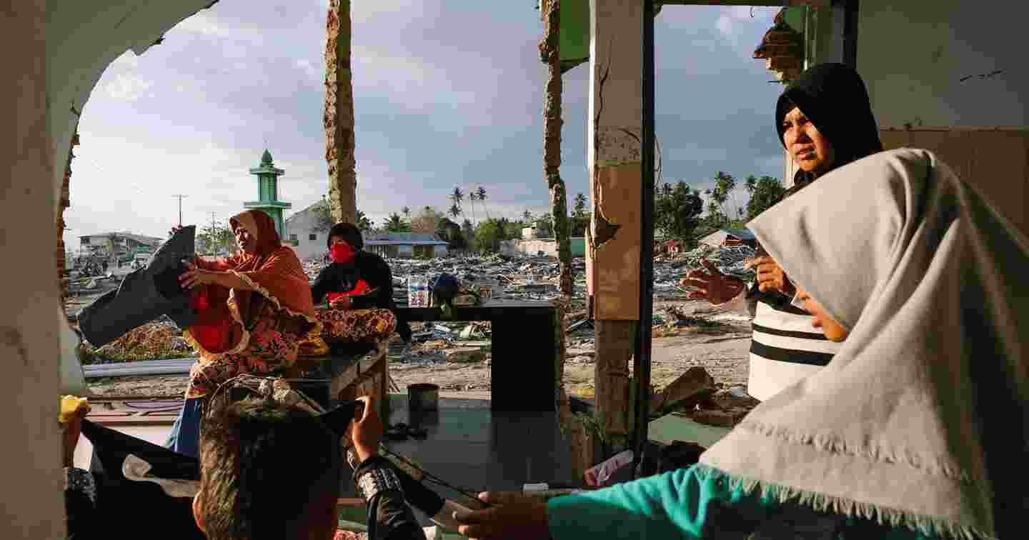 Neljä huivipäistä naista tsunamituhojen keskellä.