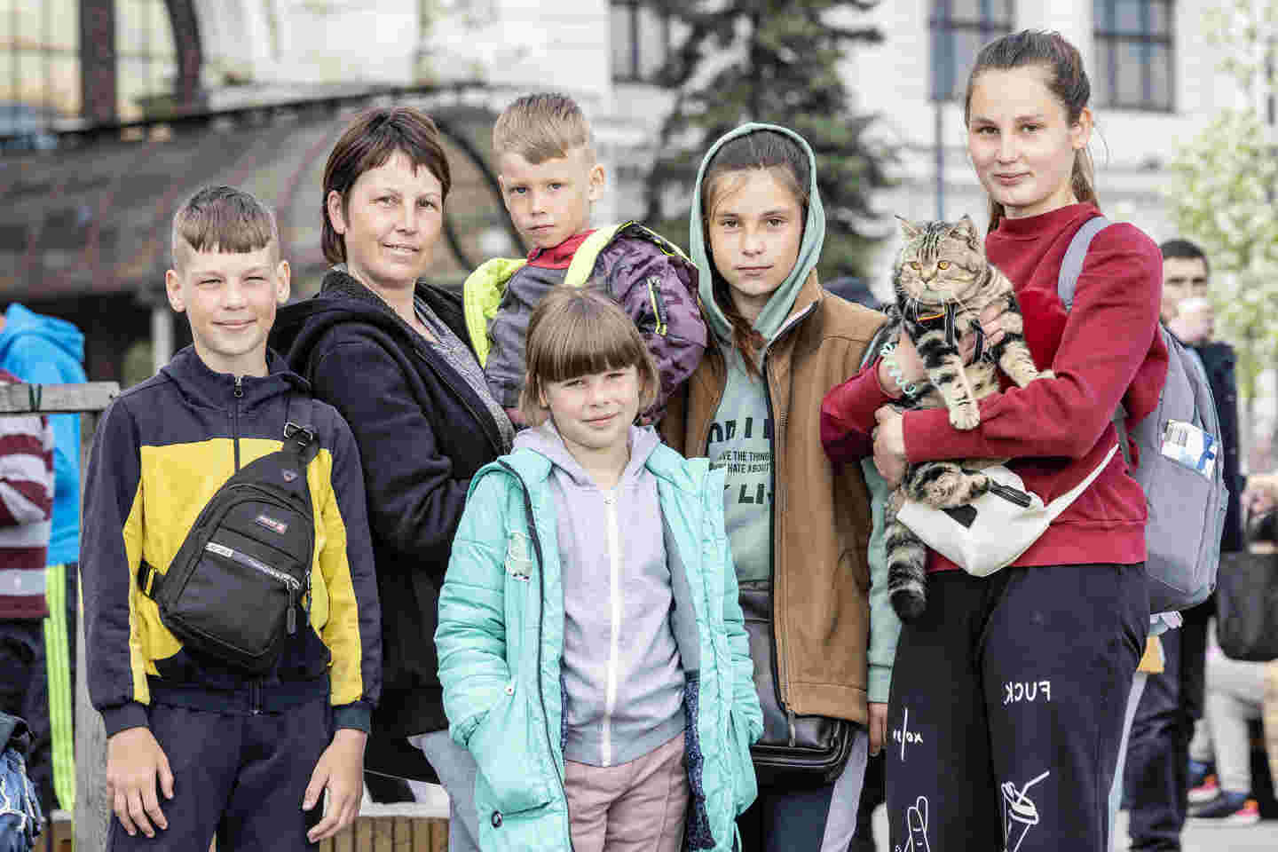 Äiti, viisi lasta ja kissa rivissä.