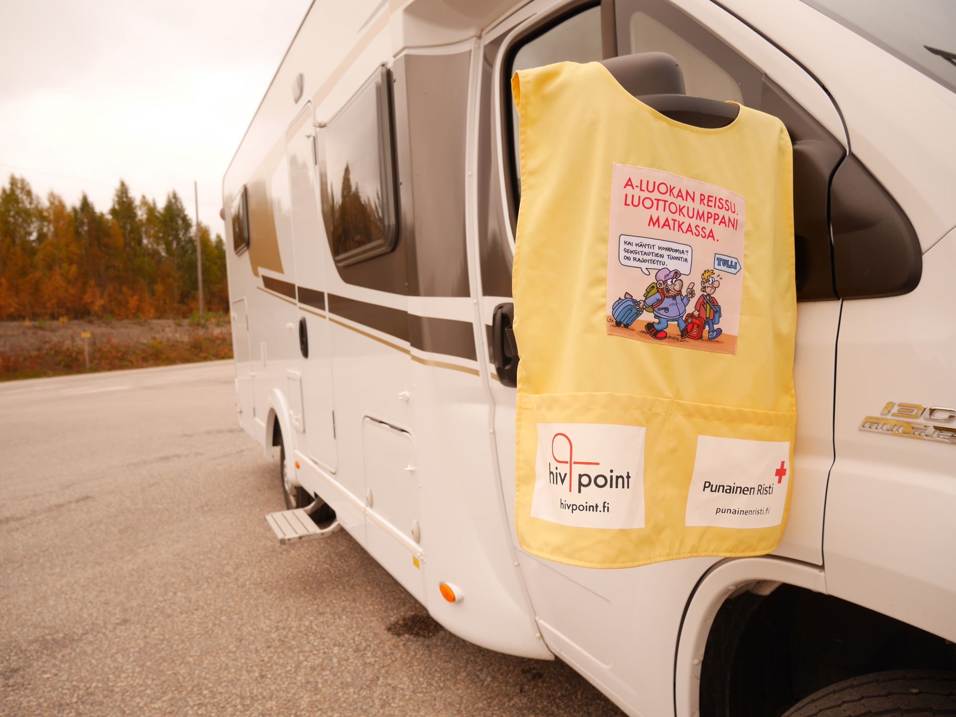 Turvaseksipartion liivi matkailuauton sivupeiliin ripustettuna.