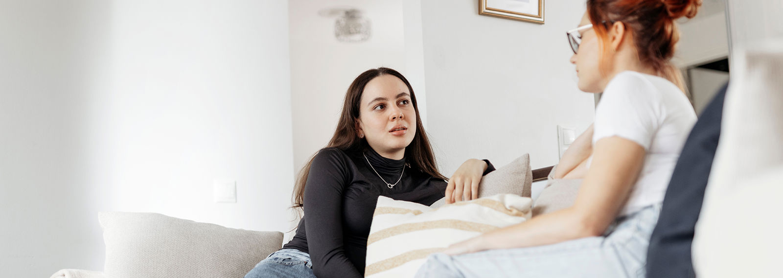 Nuori ja aikuinen keskustelevat sohvalla.