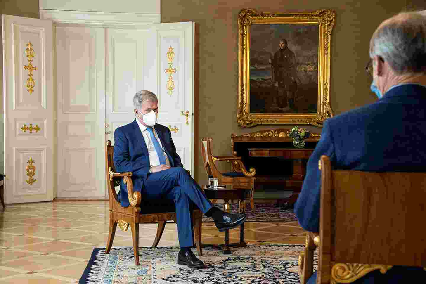 Sauli Niinistö ja Pertti Torstila istuvat tuoleilla kasvoillaan kasvomaskit.