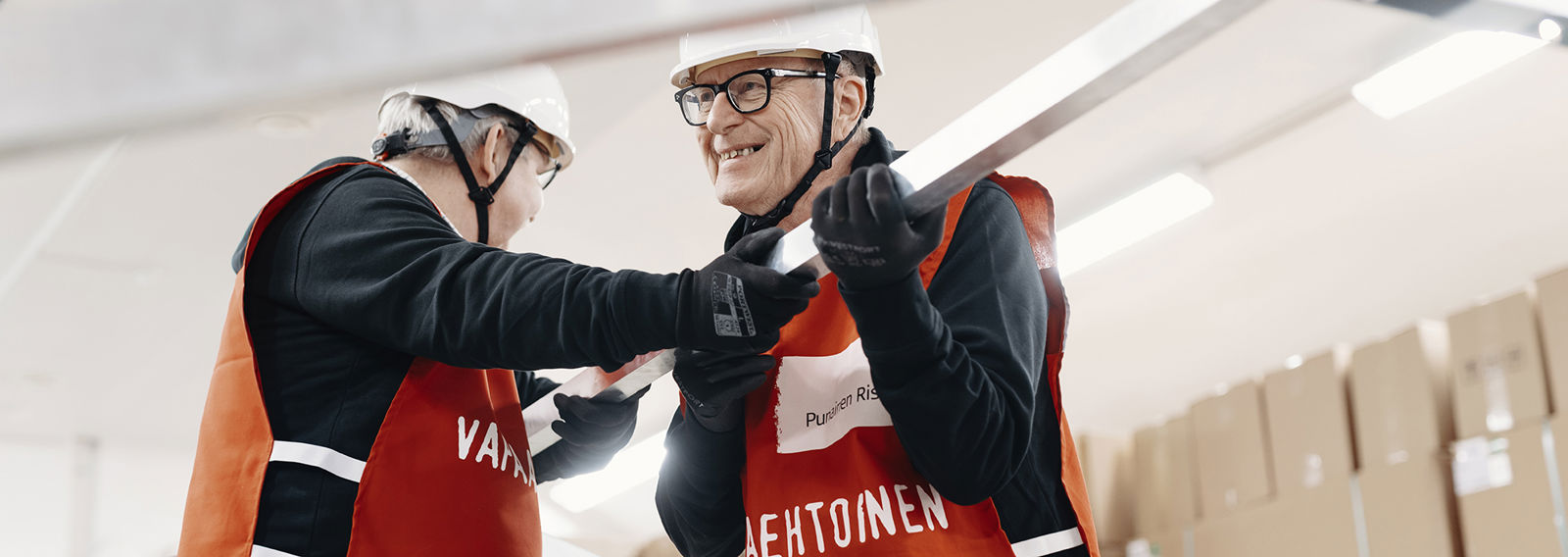 Kaksi hymyilevää Punaisen Ristin vapaaehtoista pystyttää telttaa